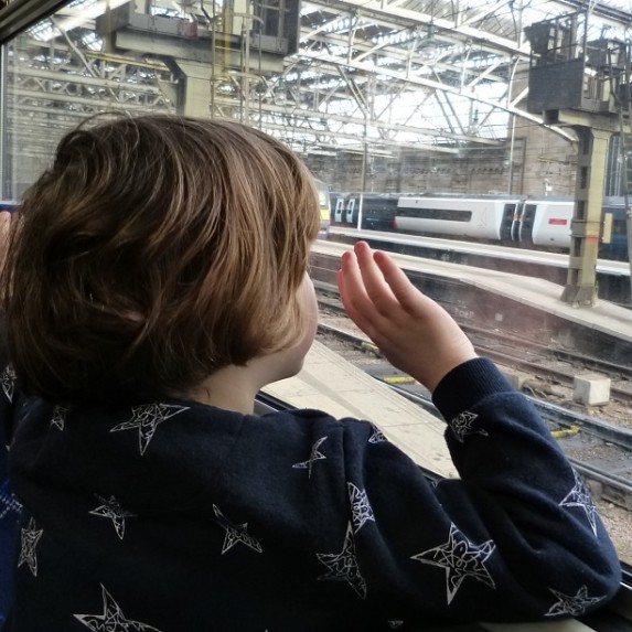 Boy looking out train window at Glasgow Central station